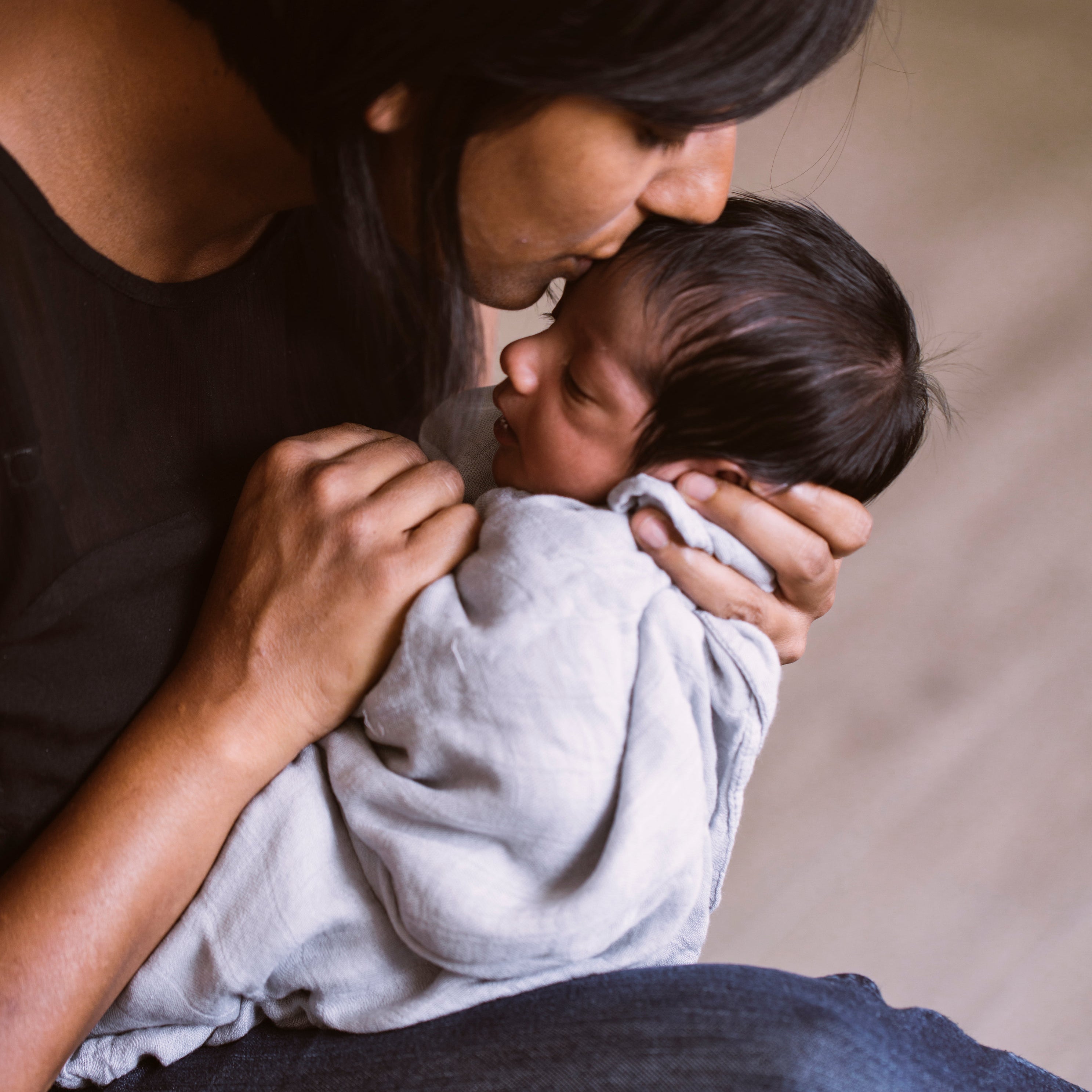Lady holding a bably. Swaddling History: Harvey Karp research into ancient Roots to Modern Trends. Atluxe Blanket and Home Co