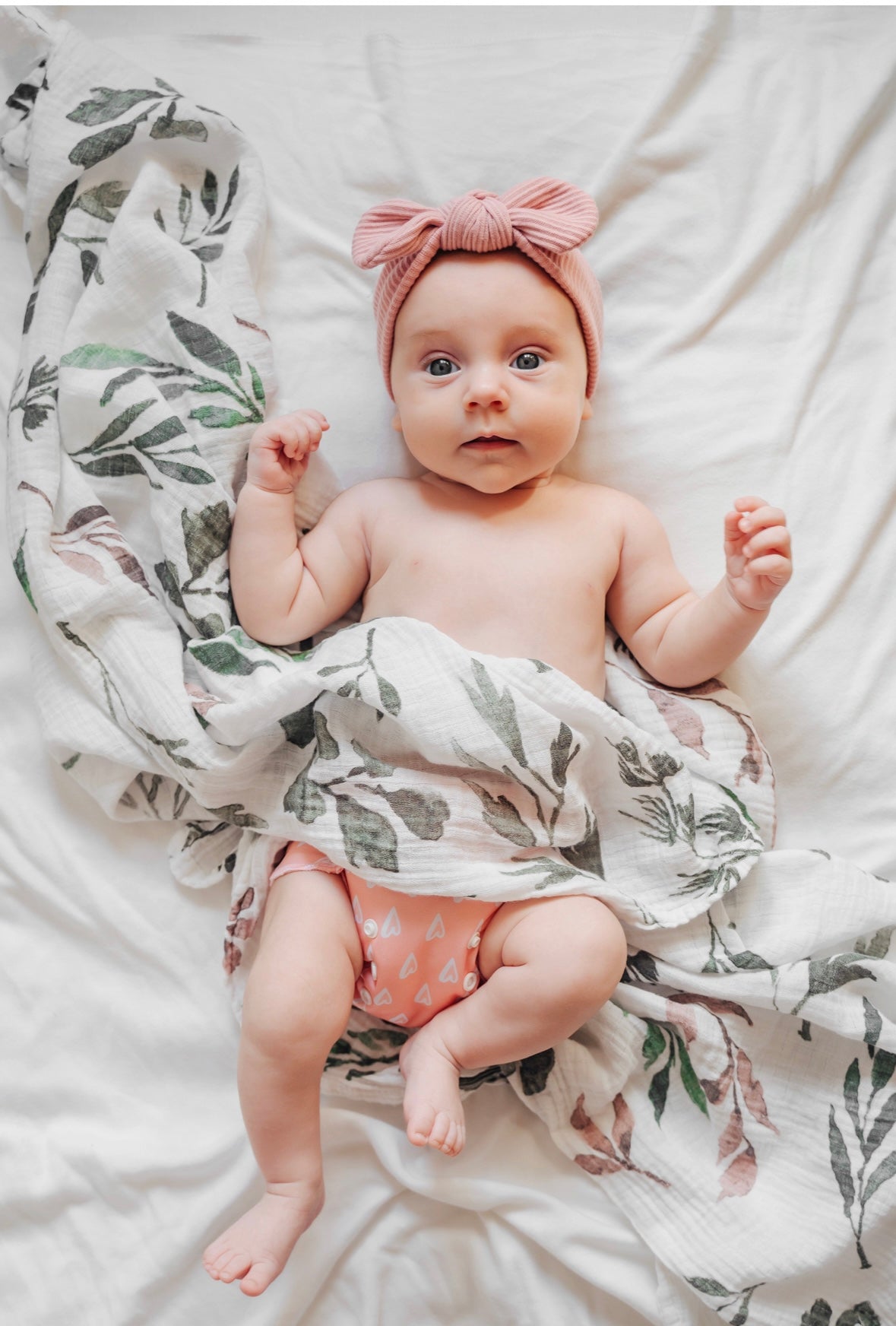 Baby about to be wrapped in atluxe bamboo swaddle