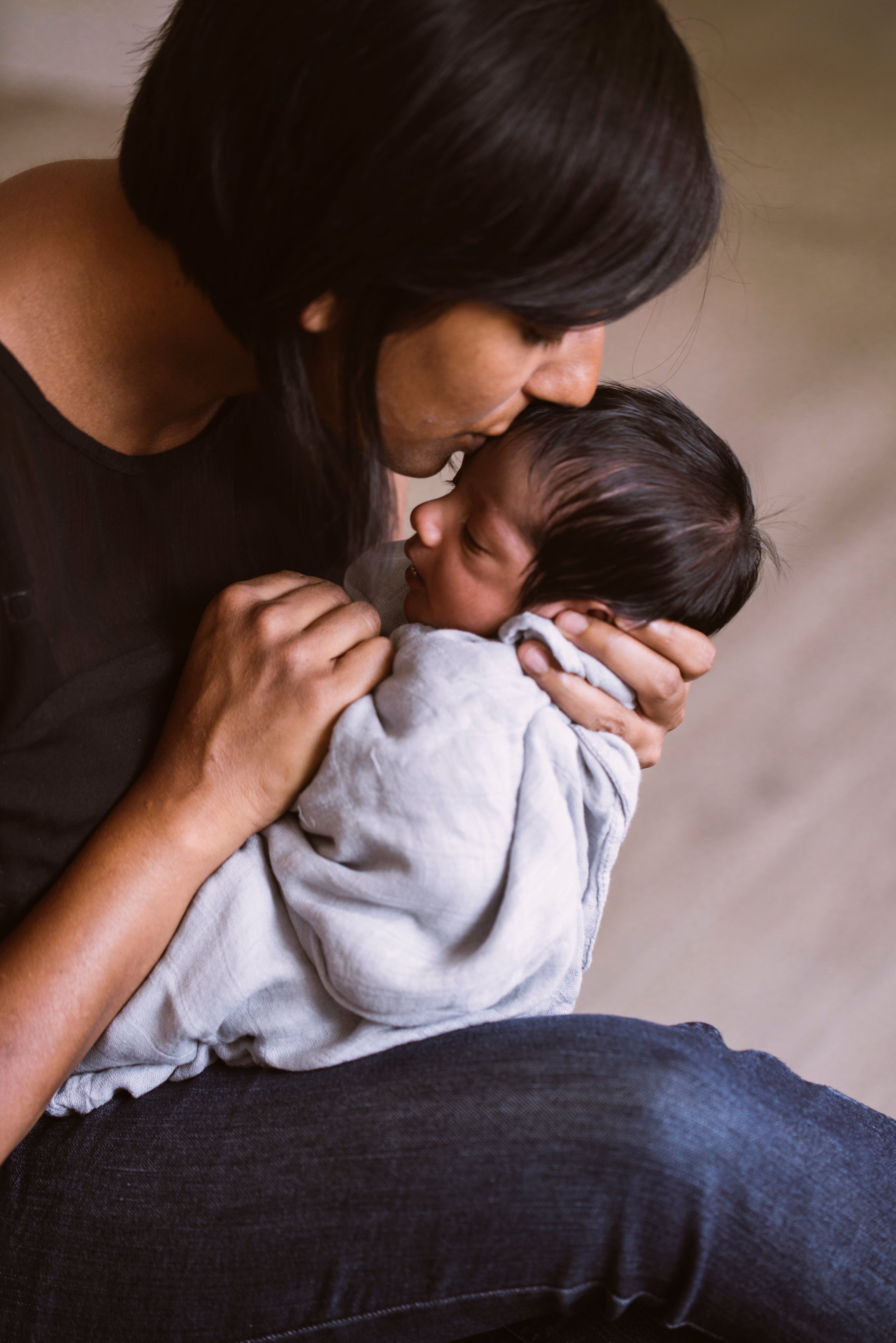 Lady holding a bably. Swaddling History: Harvey Karp research into ancient Roots to Modern Trends. Atluxe Blanket and Home Co